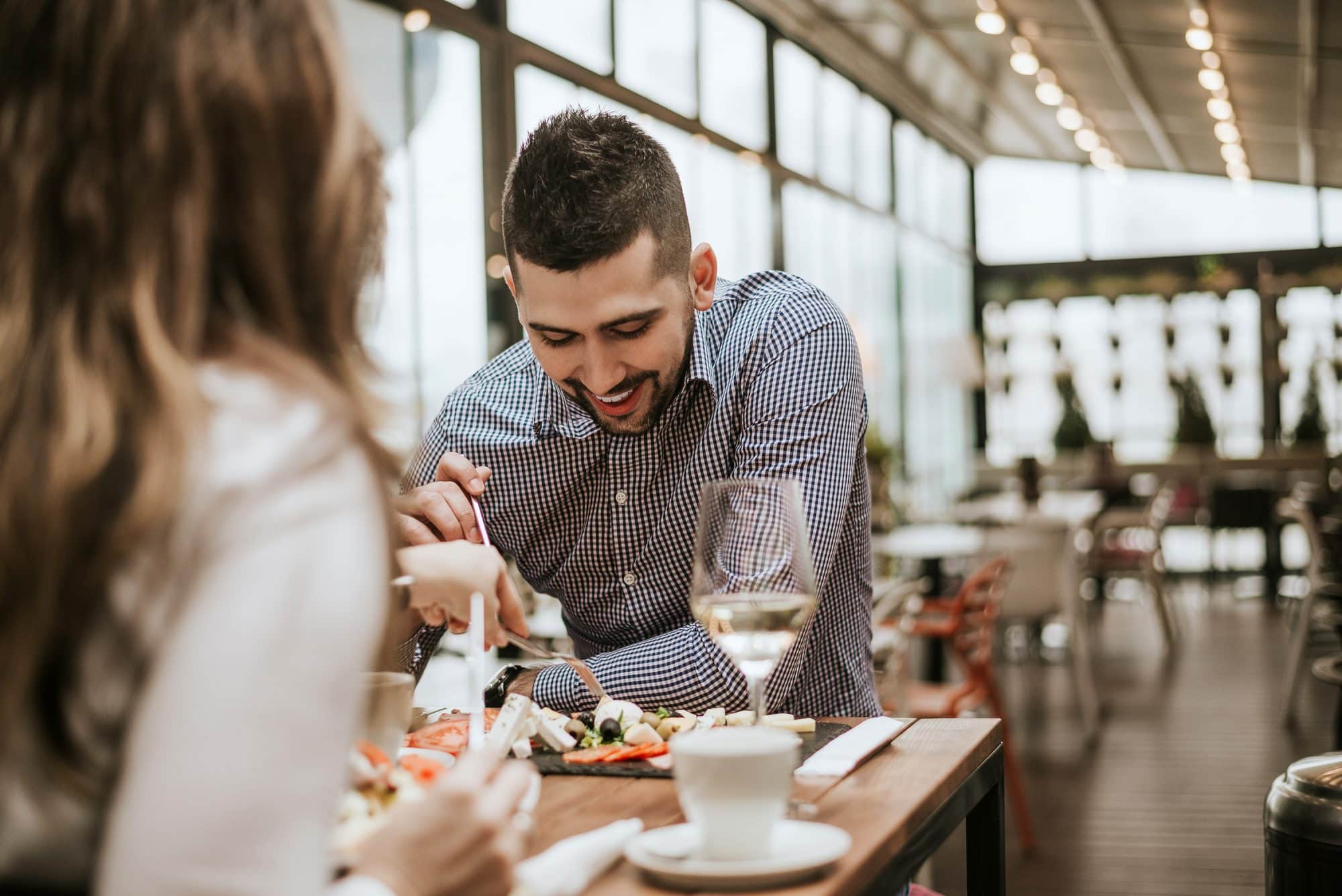 handsome man in restaurant with friend eating.